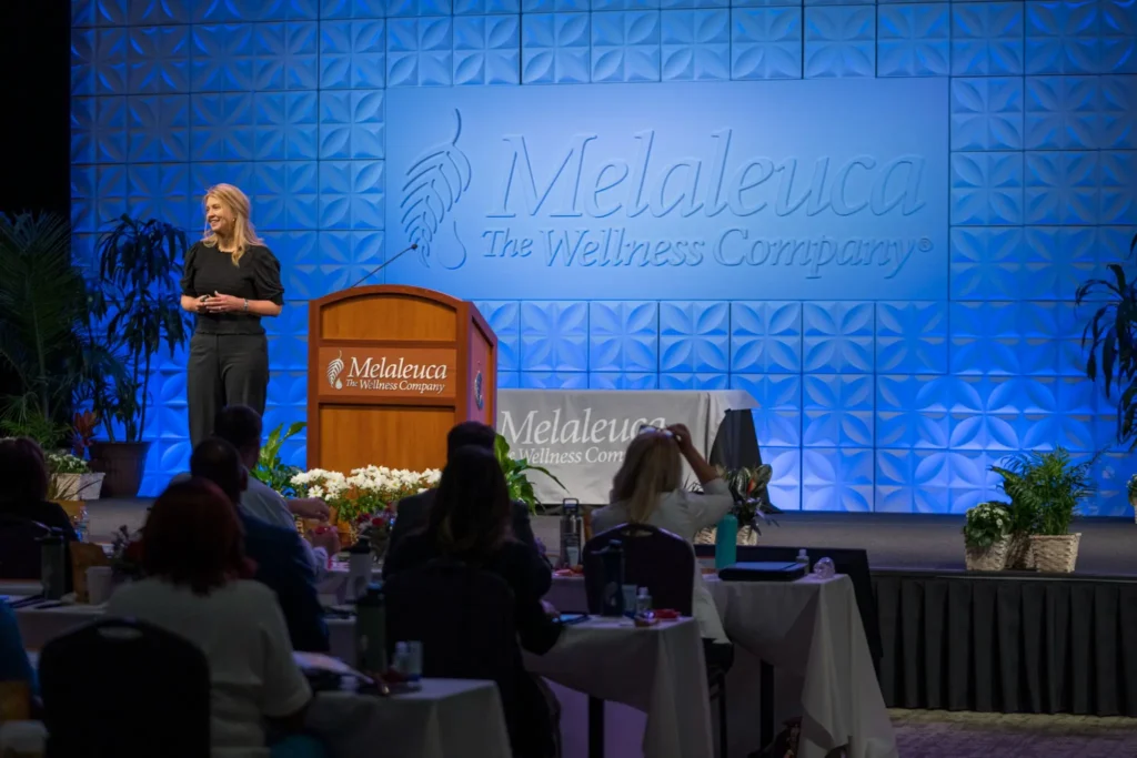 a female Melaleuca marketing executive gives a lecture at a Melaleuca event