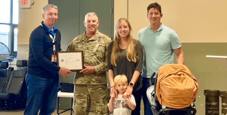 Major General Michael Garshak presented the Patriot Award to Melaleuca IT Director James Andersen, Sgt. Stephen Herriott, his wife Emily, and their two children