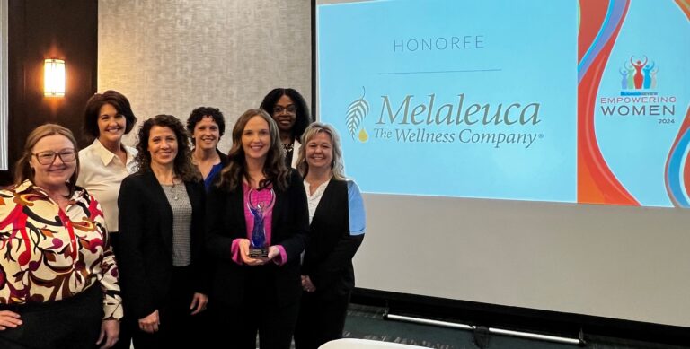 Melaleuca employees posing with Empowering Women award